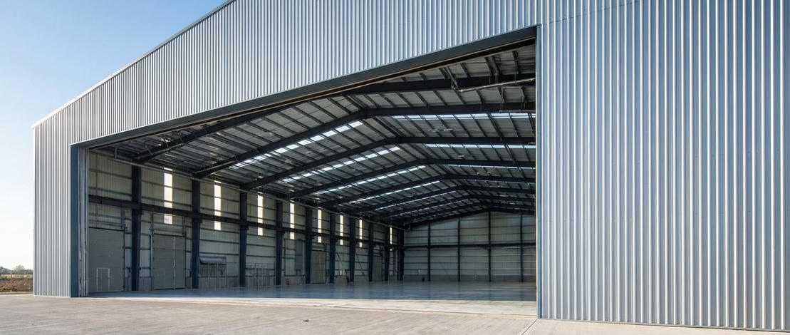 Строительство металлического ангара - стальной каркас на фоне голубого неба